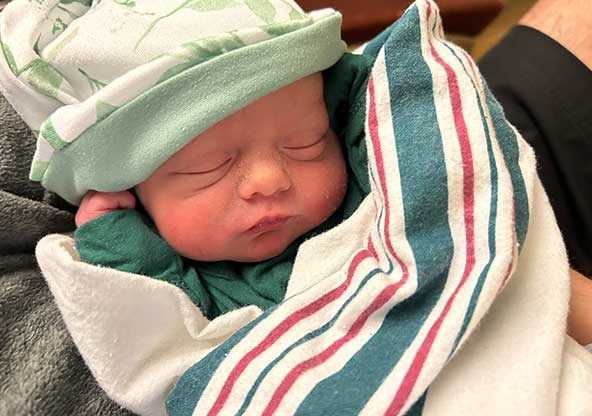 Newborn Landon Jones sleeps swaddled in a hospital blanket