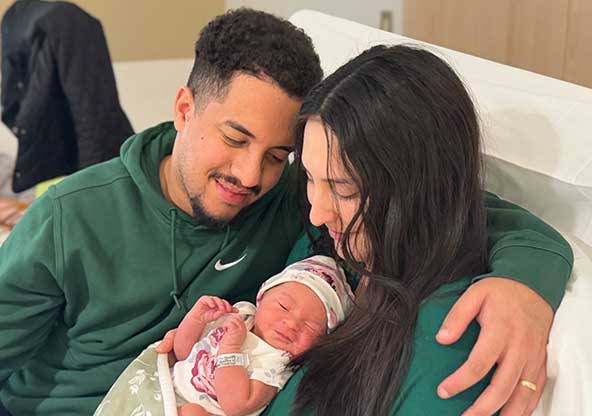 Nadya and her husband Mario holding their newborn baby girl, Elena