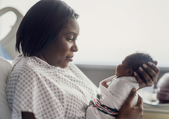 A new mom holds her newborn baby in the hospital